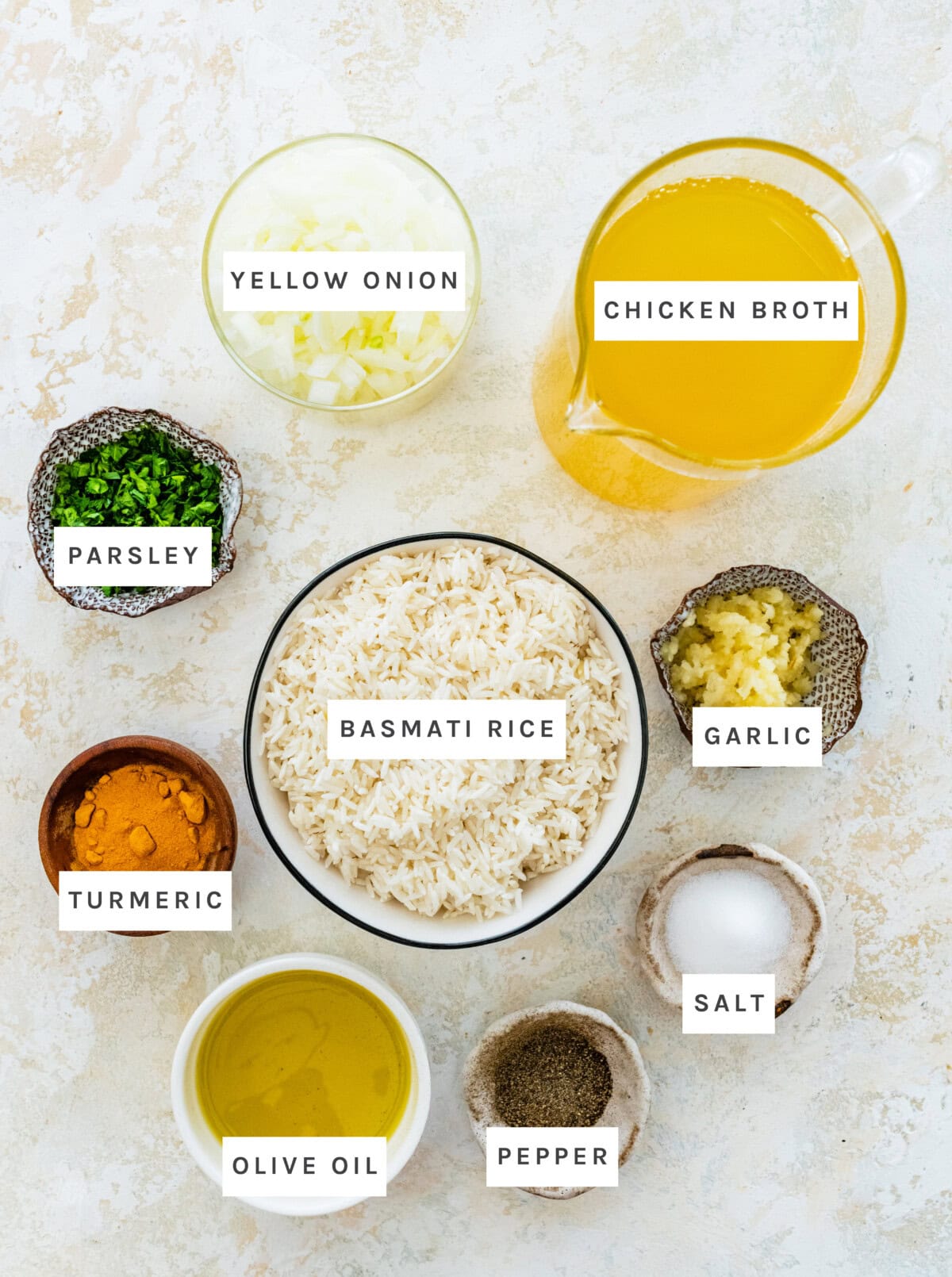 Ingredients measured out to make Turmeric Rice: Butter or olive oil, yellow onion, garlic, salt, black pepper, ground turmeric, basmati rice, low sodium chicken broth or water, parsley