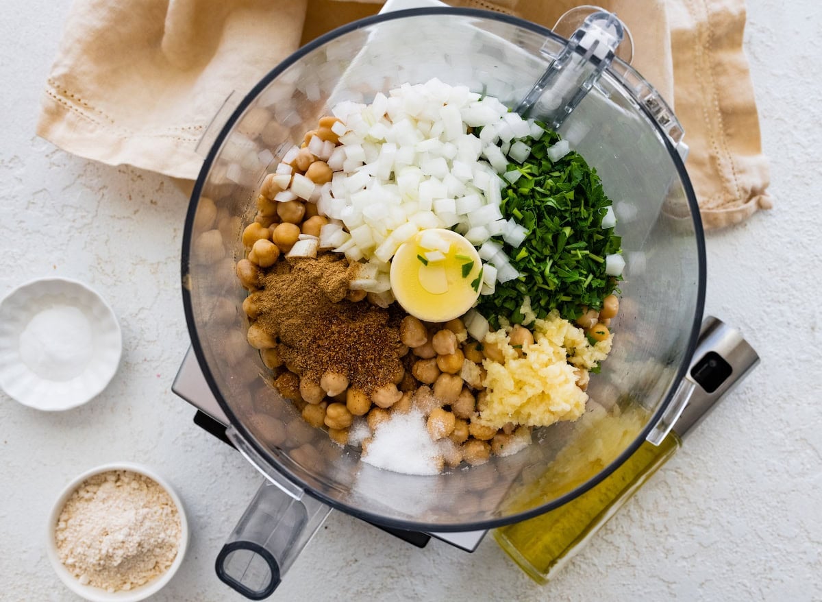 Chickpeas, herbs and spices blended in food processor to make falafel mixture.
