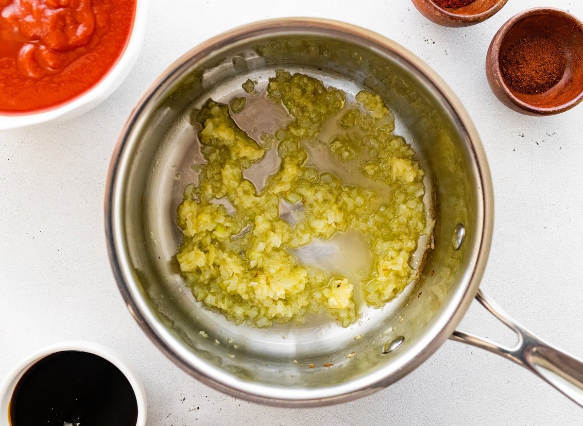 Garlic and onion sautéing in a saucepan.