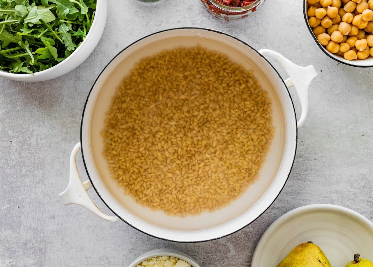 A large pot of barley cooking in water.