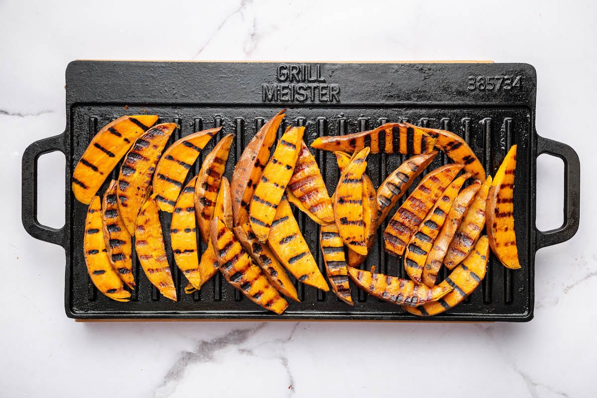 Sweet potato wedges on a grill after being cooked.
