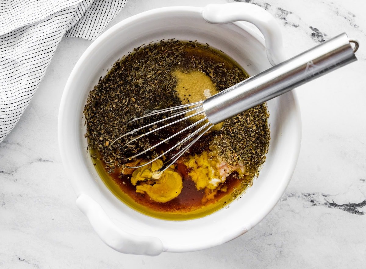Whisking herbs, Dijon mustard, and vinegar for Italian dressing.