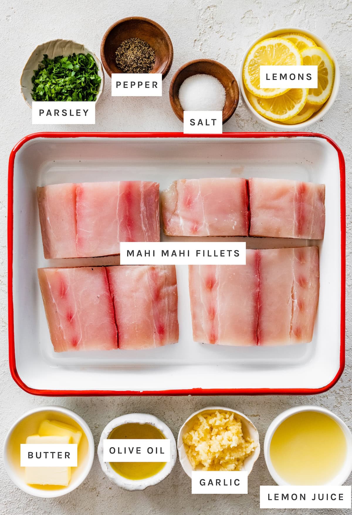 Parsley, pepper, salt, lemons, mahi mahi fillets, butter, olive oil, garlic, and lemon juice ingredients to make up Pan Seared Mahi Mahi with Lemon Garlic Sauce