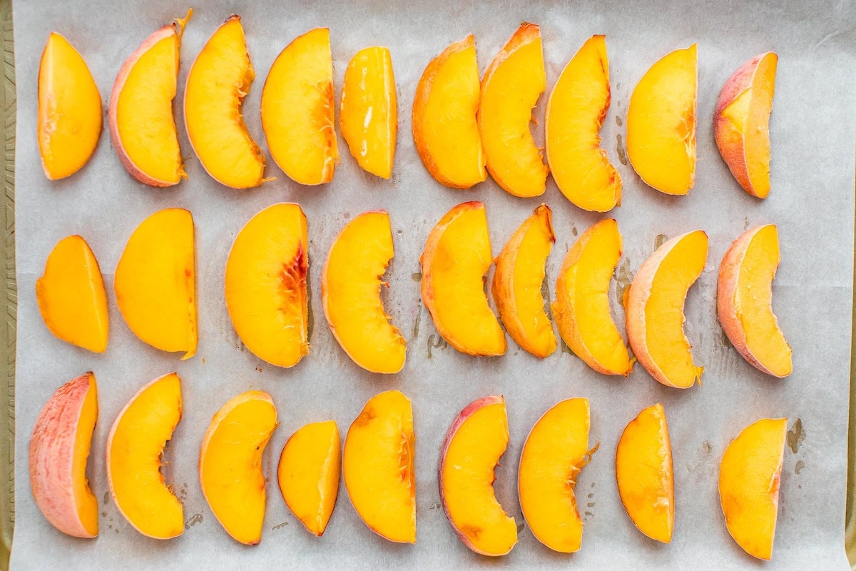 Peach slices on a baking sheet.