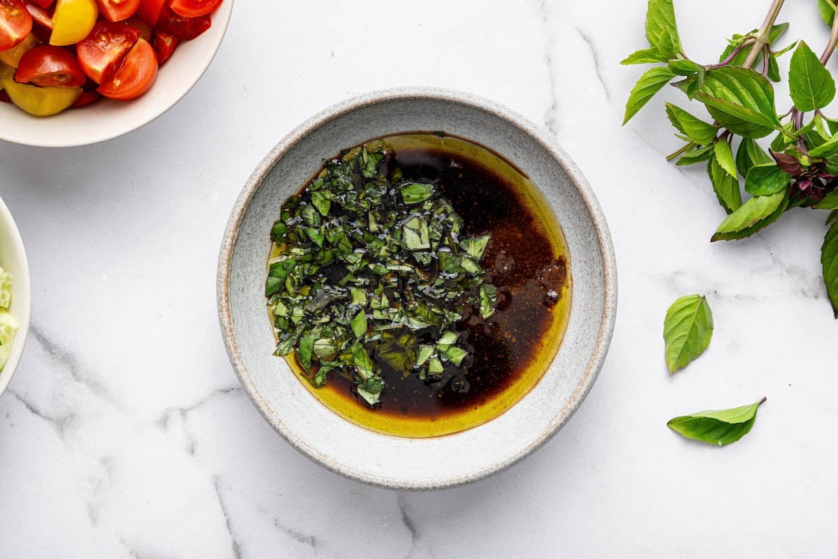 The basil balsamic dressing ingredients in a small bowl for the healthy pasta salad.