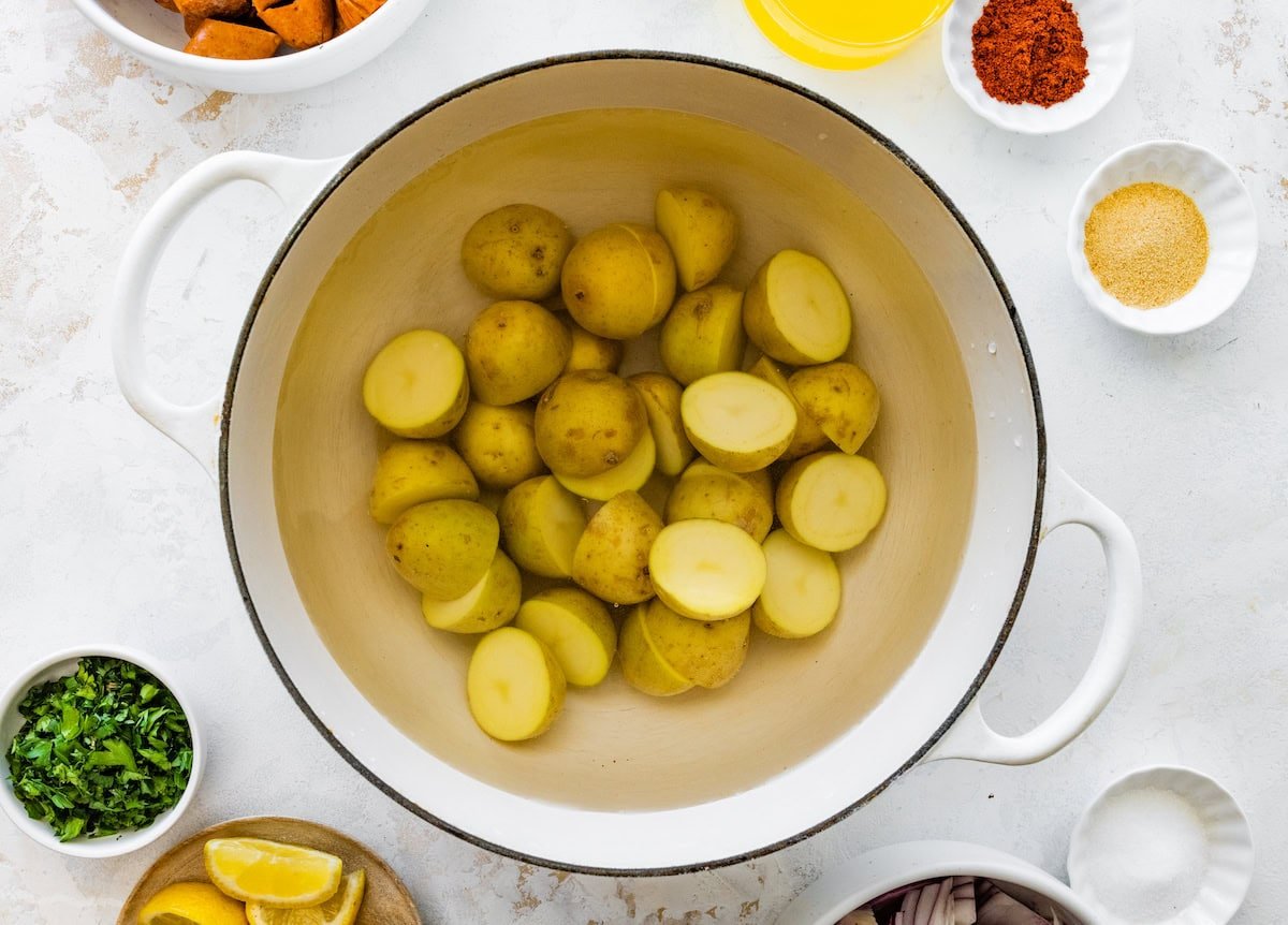 Boiled baby potatoes in a strainer over a large pot.