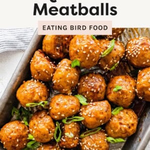 Tray of glazed BBQ chicken meatballs topped with sesame seeds and sliced green onions, labeled “Healthy BBQ Chicken Meatballs.”