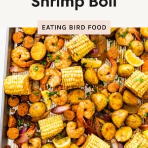Sheet pan with shrimp, sausage, potatoes, corn, red onion, and lemon slices, garnished with parsley. Text reads “Easy Sheet Pan Shrimp Boil” and “Ready in about 30 minutes!”