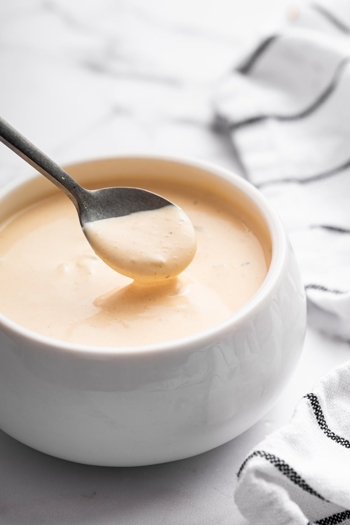 A spoonful of Big Mac sauce being lifted from a bowl