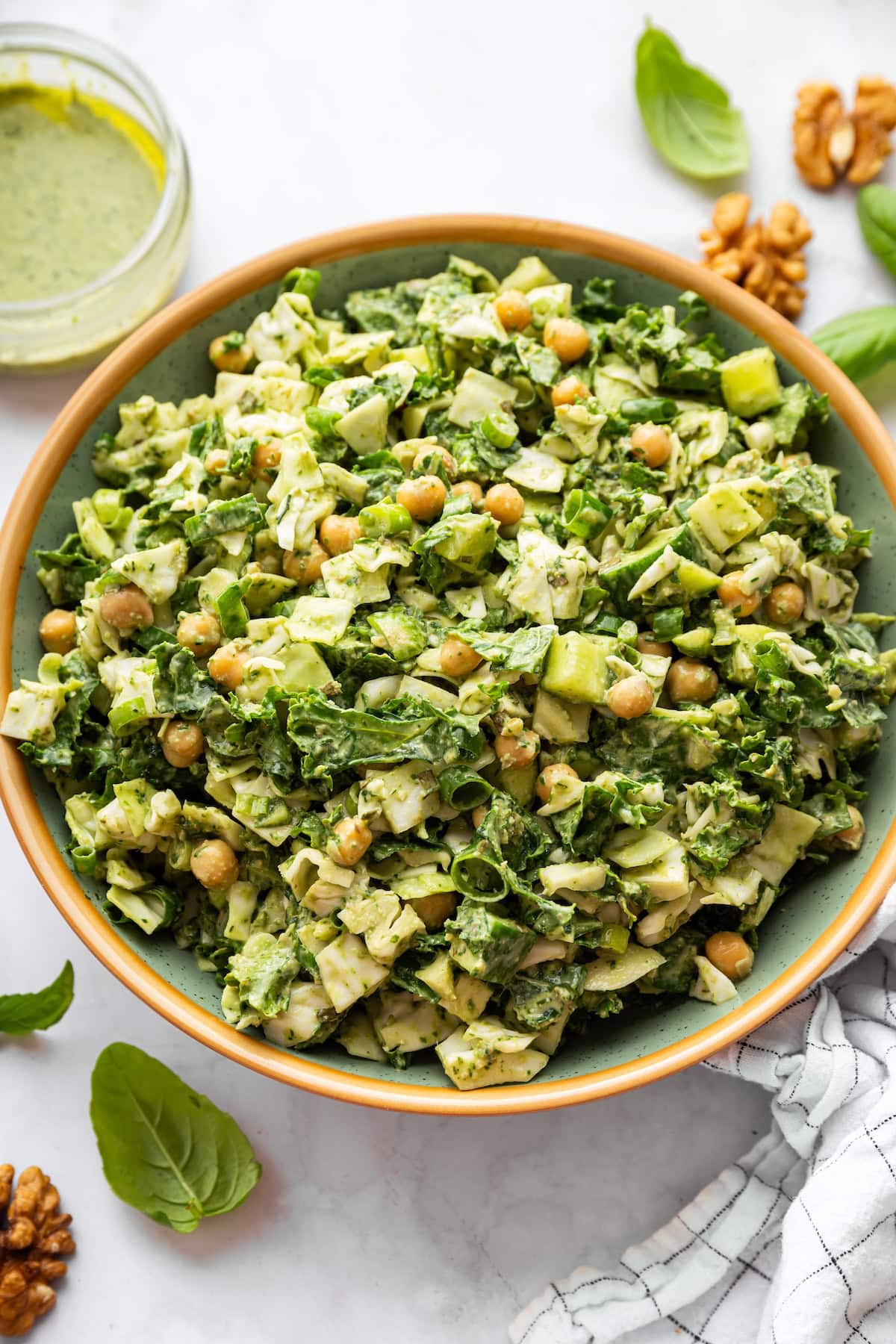 Green goddess salad showing finely chopped greens, chickpeas, and creamy dressing.