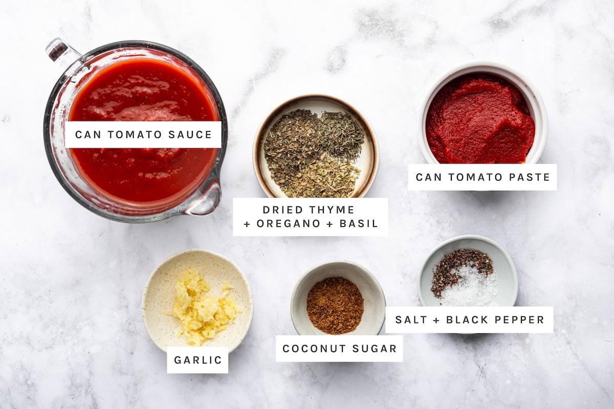 Homemade Pizza Sauce ingredients: Can tomato sauce, can tomato paste, dried thyme, dried oregano, dried basil, garlic, coconut sugar, salt, black pepper.