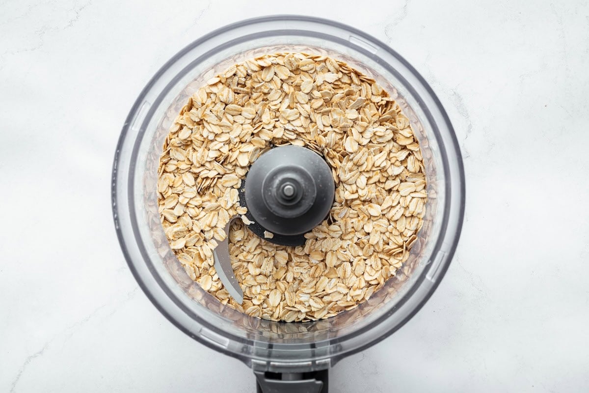 A food processor with rolled oats.