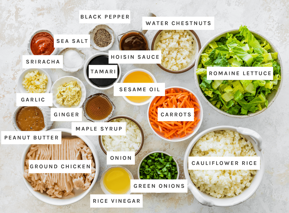 Chicken Lettuce Wrap Bowls ingredients: Sriracha, sea salt, black pepper, water chestnuts, hoisin sauce, tamari, sesame oil, romaine lettuce, carrots, cauliflower rice, green onions, rice vinegar, onion, maple syrup, ginger, garlic, peanut butter, ground chicken
