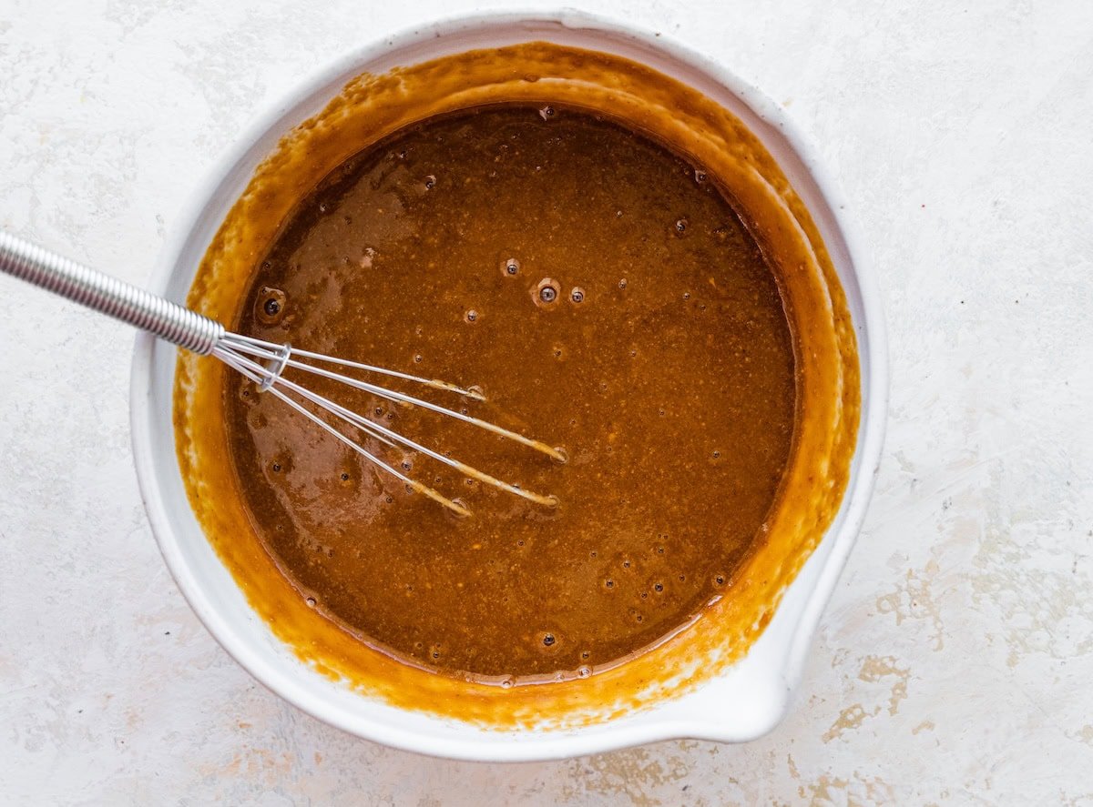 Peanut sauce mixed together in a small mixing bowl with a whisk.