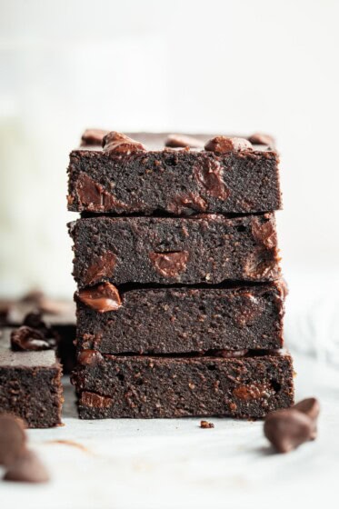 Stack of four cottage cheese brownies showing moist texture.