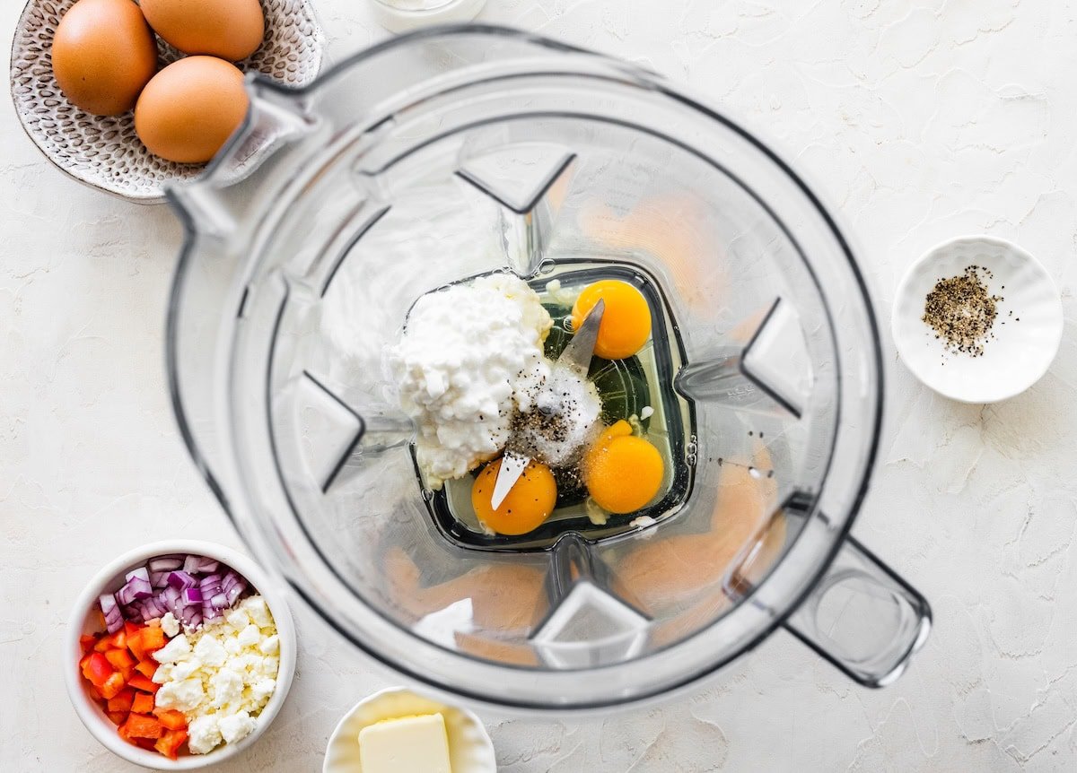 Eggs and cottage cheese blended together in a blender jar before mixing.