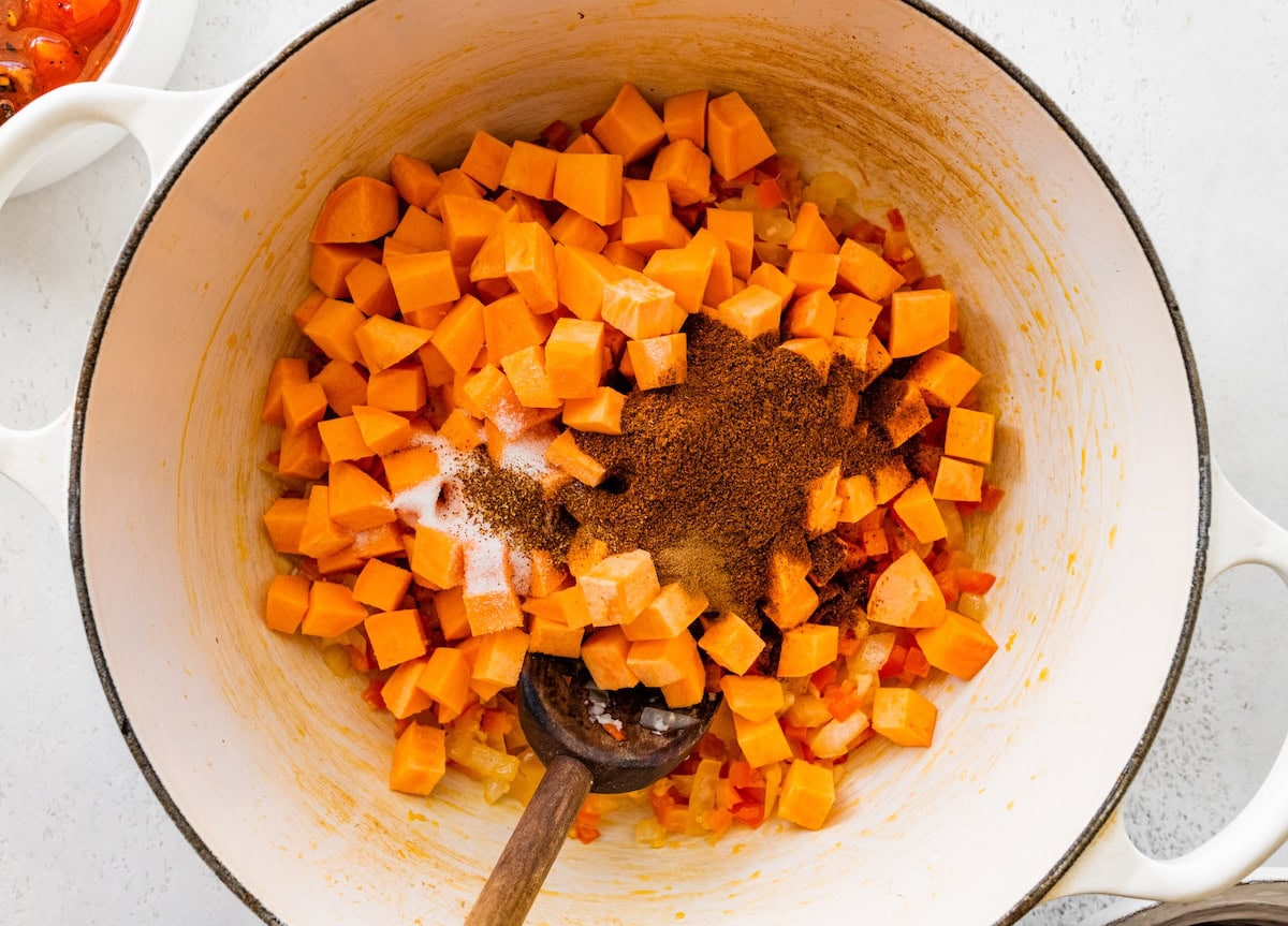 A large pot with diced sweet potato and plenty of spices.