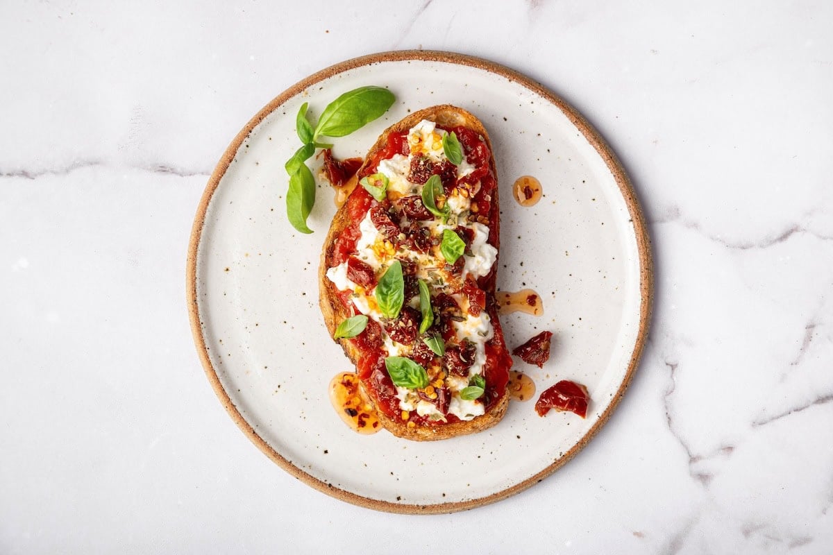 Cottage cheese toast with marinara, sun dried tomatoes, oregano, garlic powder, and fresh basil for a pizza-inspired variation.