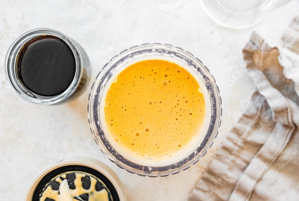 Blended pumpkin spice latte mixture in a glass blender jar.