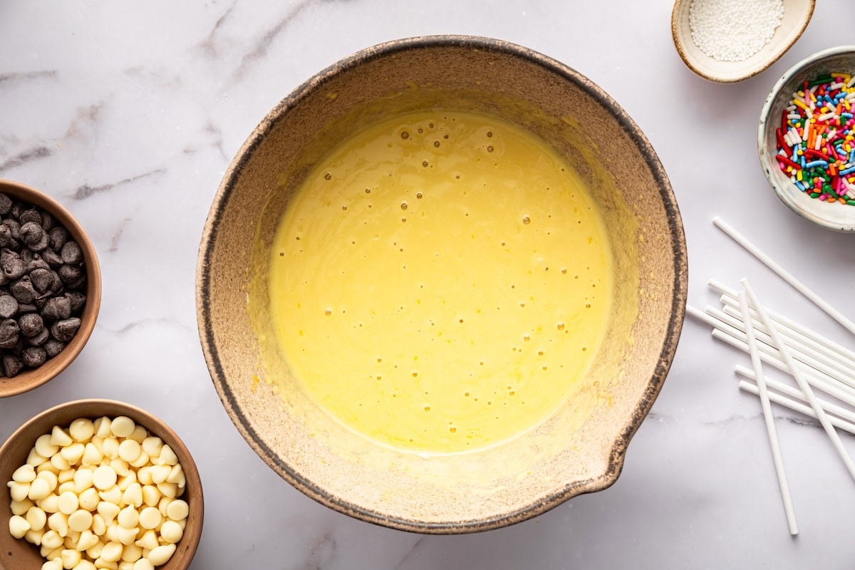 Wet ingredients mixed in a bowl for homemade cake pop batter.