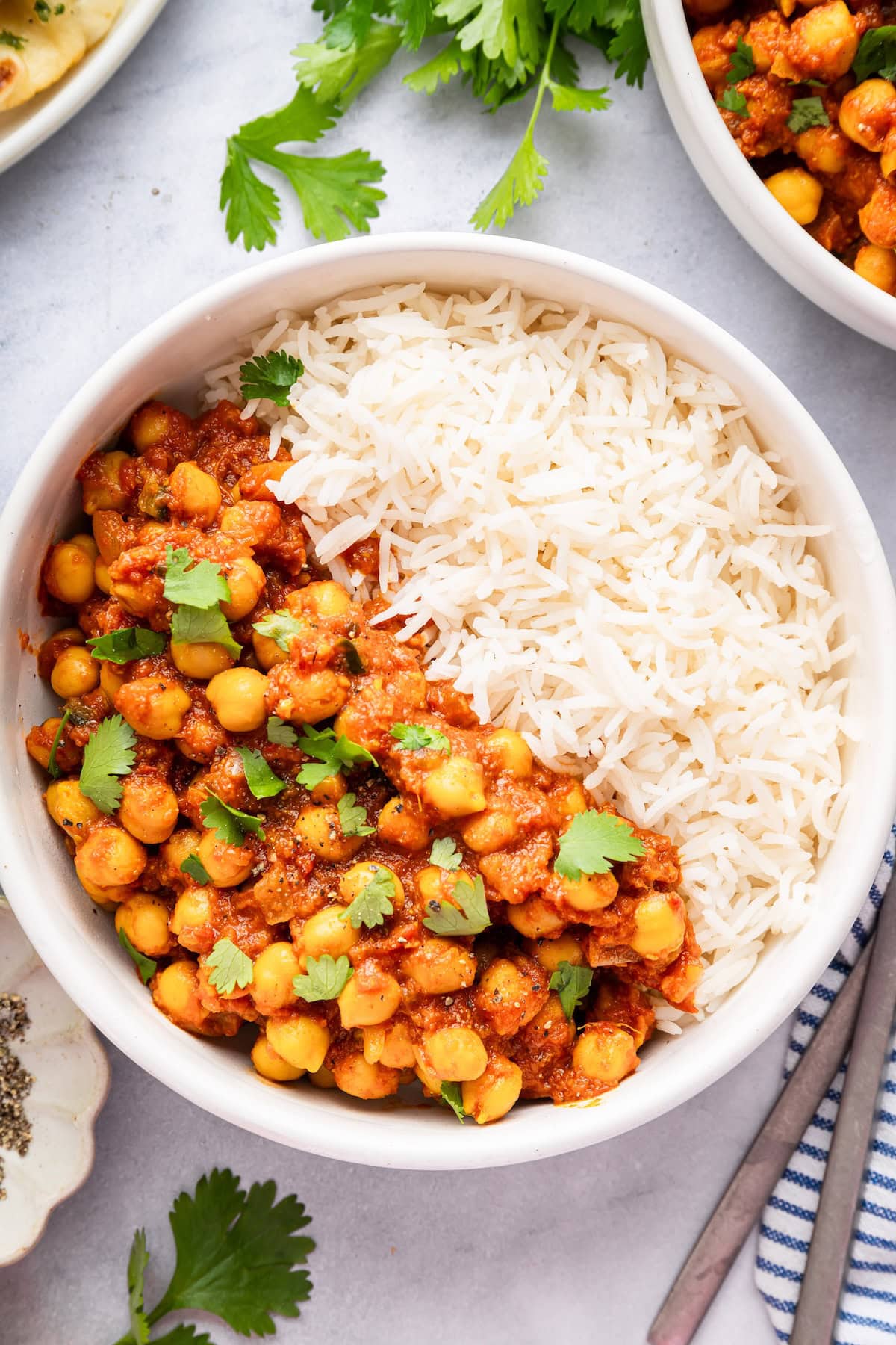 Chana masala served with fluffy white rice and garnished with fresh cilantro.