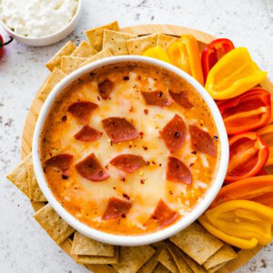 Cottage cheese pizza bowl topped with melted mozzarella and turkey pepperoni, served with mini bell peppers and whole-grain crackers for dipping.