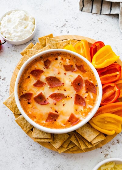 Cottage cheese pizza bowl topped with melted mozzarella and turkey pepperoni, served with mini bell peppers and whole-grain crackers for dipping.