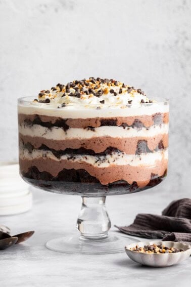 Assembled chocolate trifle showing layers of brownies, pudding, and whipped topping in a glass trifle dish.