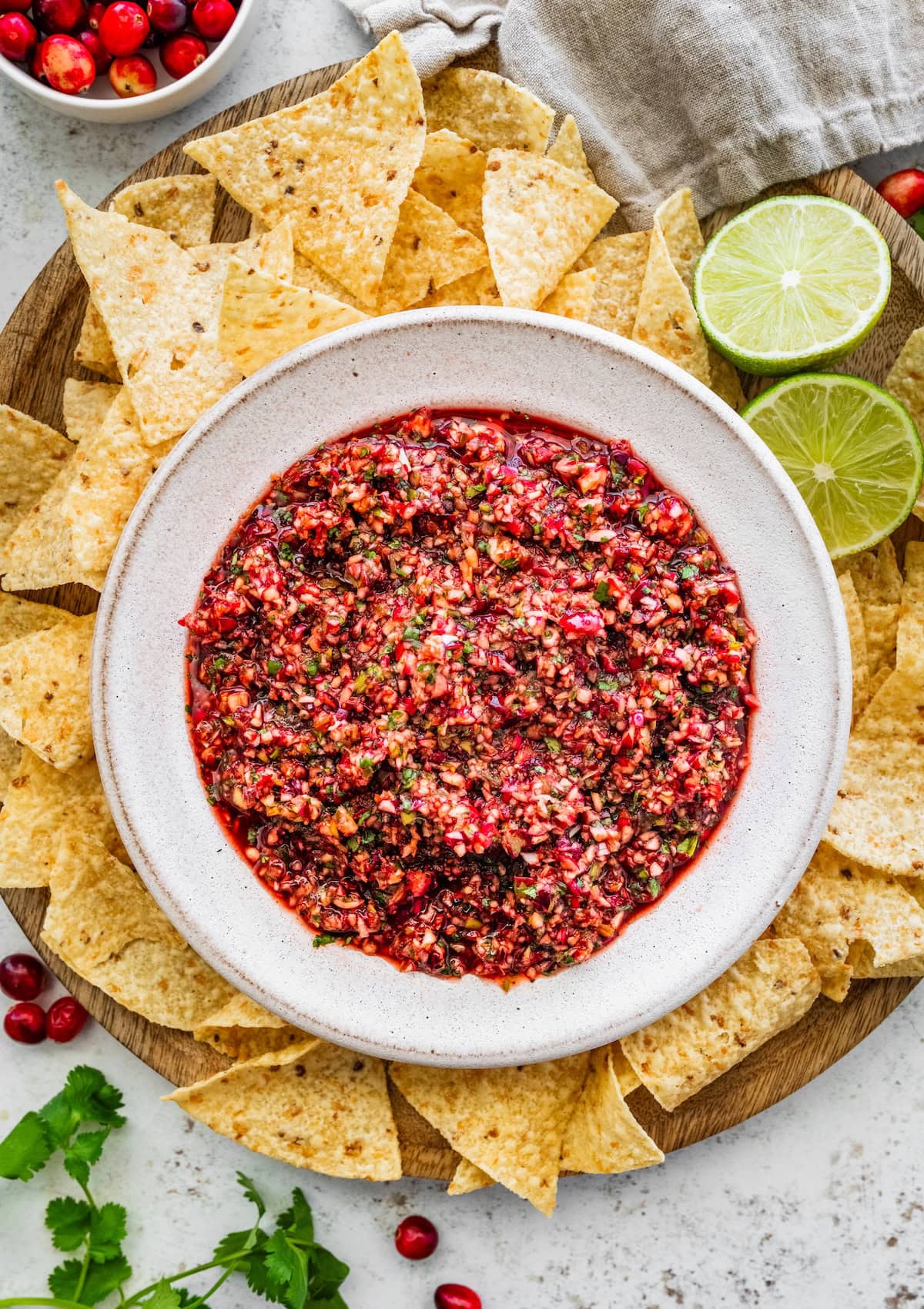 Cranberry salsa in a bowl with chips on the side for dipping.