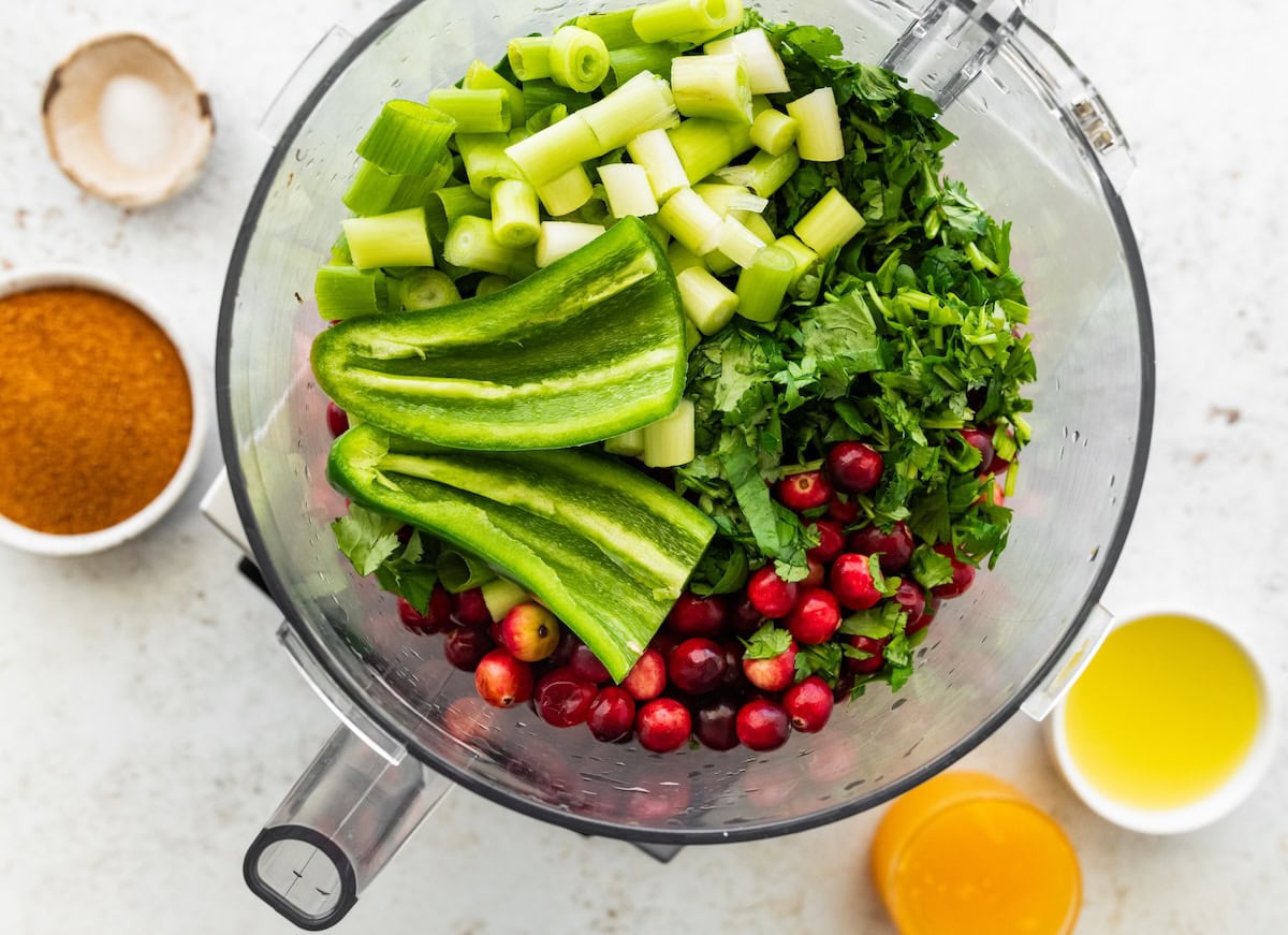 Fresh cranberries, cilantro, jalapeño and green onion in a food processor before blending.