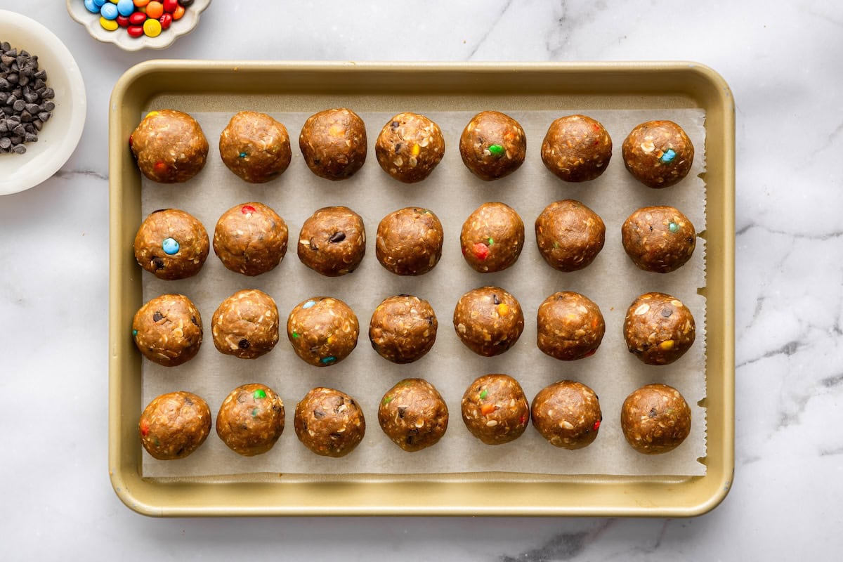 Monster cookie protein balls arranged on a baking sheet for easy no bake meal prep.