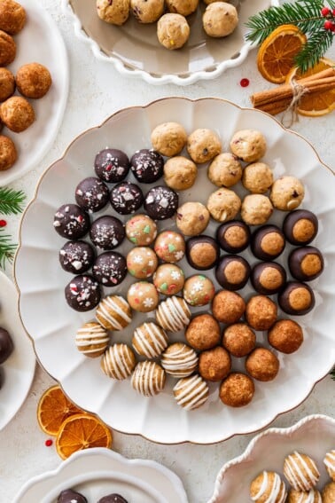 6 varieties of holiday protein balls on a white serving platter.