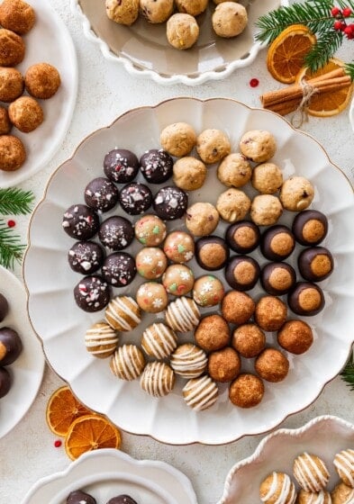 6 varieties of holiday protein balls on a white serving platter.