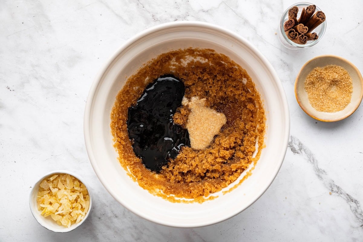 A medium mixing bowl of mixed brown sugar, coconut oil, molasses, and flaxseed egg.