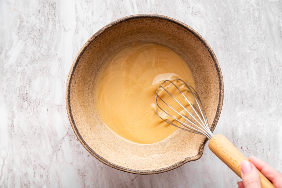 Wet ingredients used for no bake cookies being whisked in a bowl.