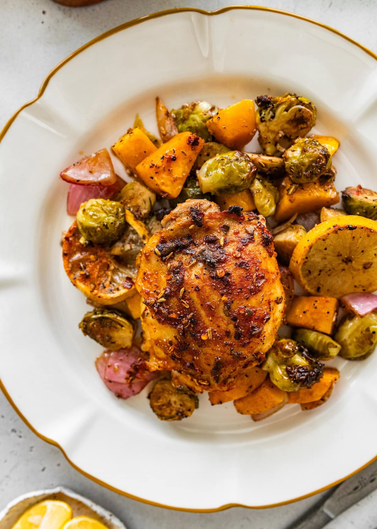 sheet pan chicken with veggies Plated sheet pan chicken and veggies with roasted Brussels sprouts and butternut squash.