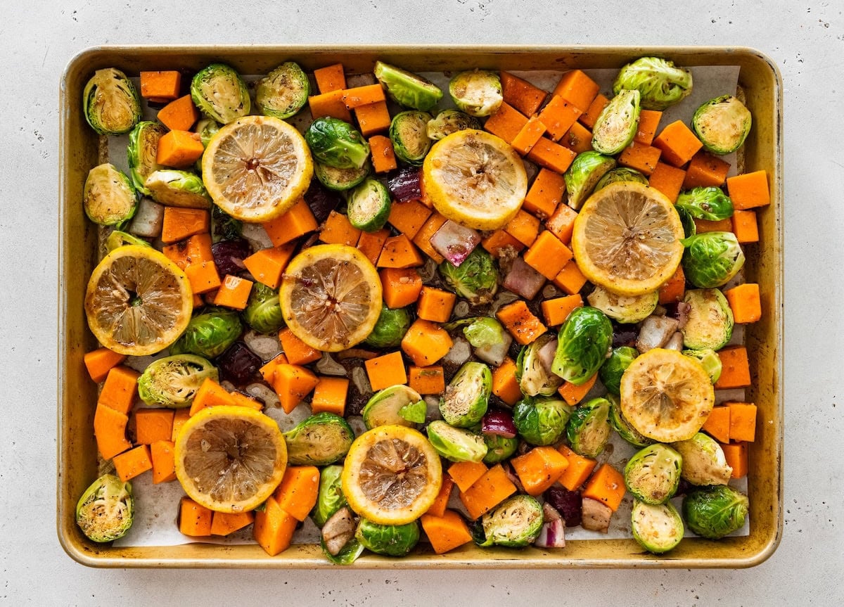 Roasted chicken and vegetables Roasted chicken and vegetables spread across a sheet pan before baking.