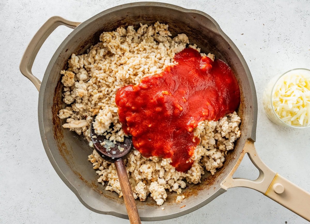 A pan with cooked ground turkey and tomato sauce.