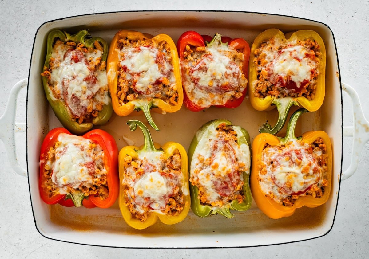 A pan of cooked turkey stuffed peppers with melted cheese.