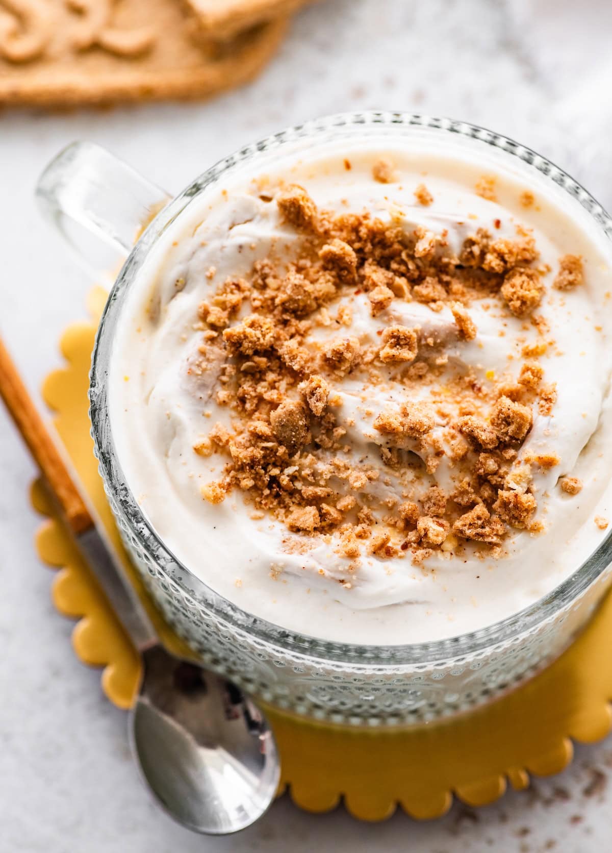 A glass container with crumbled cookies and greek yogurt.