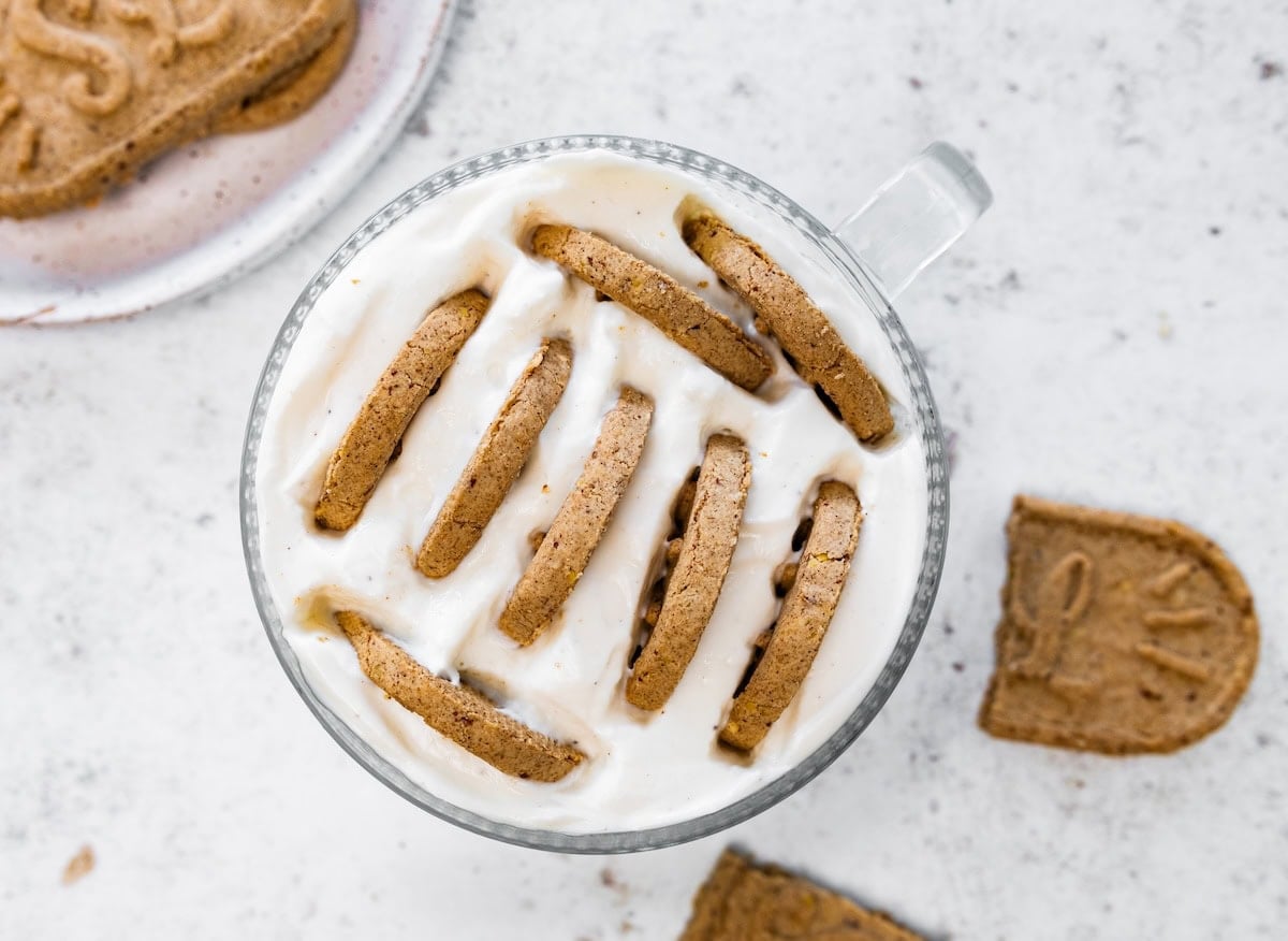 Multiple cookies emerged in greek yogurt in a glass cup.