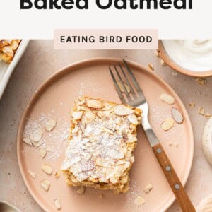 Slice of almond croissant baked oatmeal topped with powdered sugar and sliced almonds on a plate.