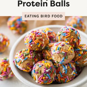 Bowl of birthday cake protein balls coated in colorful sprinkles on a light background.
