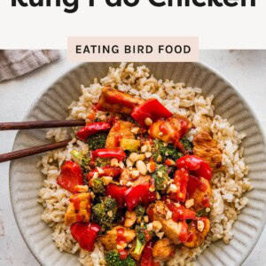 Bowl of kung pao chicken with broccoli, red peppers, and peanuts over brown rice