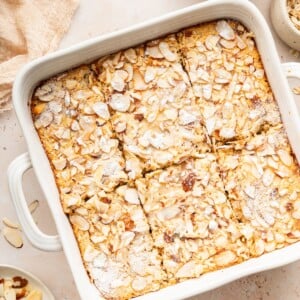 Square pan of baked oatmeal topped with sliced almonds and sugar.