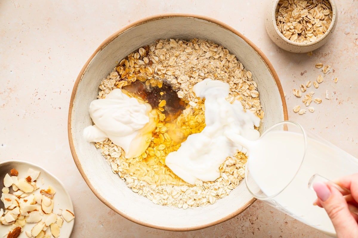 Wet ingredients for baked oatmeal in mixing bowl with almond milk.