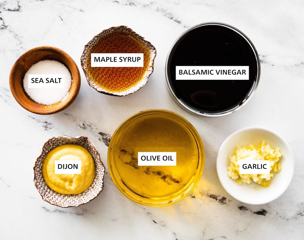 Ingredients measured out to make Balsamic Vinaigrette: balsamic vinegar, garlic, maple syrup, olive oil, sea salt and dijon.