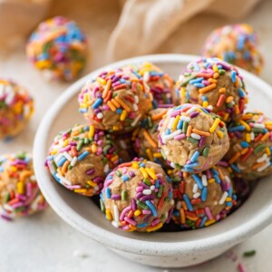 A bowl full of birthday cake protein balls with colorful sprinkles.