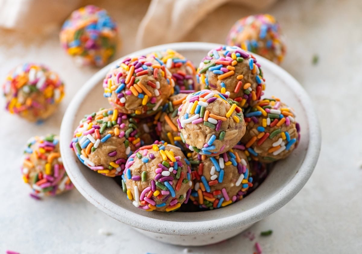 A bowl full of birthday cake protein balls with colorful sprinkles.