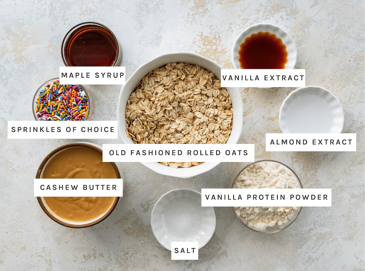 Old fashioned rolled oats, cashew butter, maple syrup, vanilla protein powder, vanilla extract, almond extract, salt, sprinkles of choice